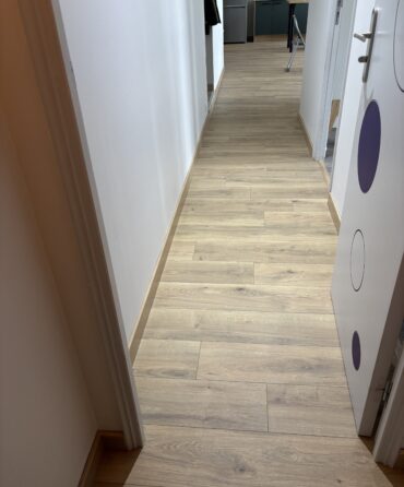 Pose d’un parquet stratifié dans un dégagement avec finition raboutée des plinthes